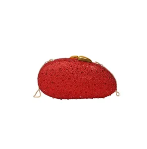 Sac de soirée strass rouge avec chaîne dorée et fermoir en forme de feuille.