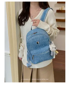 Denim mini backpack detail showcasing sparkle fabric, metal square accent and cute knit bear charm.