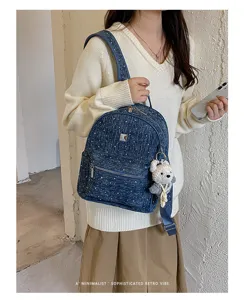 Detailed view of stylish denim backpack with cute bear pendant and casual retro design.