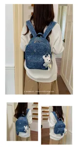 Close-up detail view of casual denim backpack with cute bear pendant, back view showcase