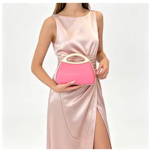 Elegant pink acrylic hard-shell handbag with gold metal handle and chain for women detail shot.