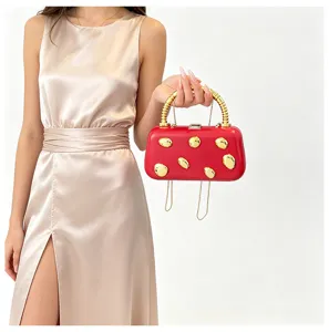 Red hard-shell clutch bag featuring chic gold-tone studs and elegant bamboo handle detail.