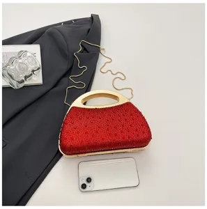 Red rhinestone evening clutch bag with gold metal handle and chain strap for women.