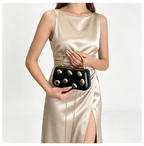 Elegant black hard box clutch bag with gold studs and metal handle for women evening party.