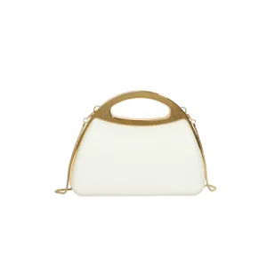 Close-up detail of the elegant white acrylic hard-shell evening bag with gold metal handle.