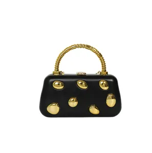 Elegant black hard box evening clutch with gold ridged top handle and metallic gold studs for women.