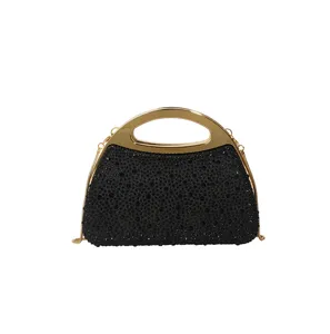 Black rhinestone evening bag with gold metal handle and chain strap for party dress.