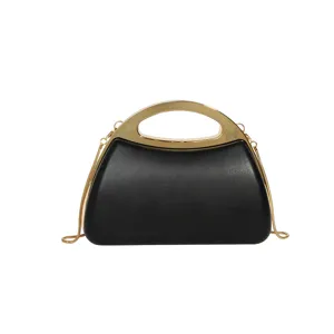 Black acrylic hard case evening bag detail, featuring a luxury gold metal handle and chain.