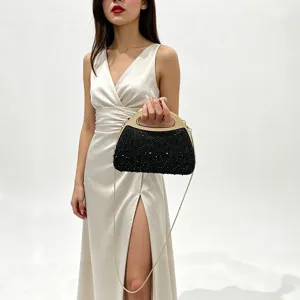 Black rhinestone evening bag with metal handle and chain strap for parties and weddings.