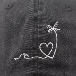 Close-up detail of washed cotton baseball hat with white wave heart palm tree embroidery.