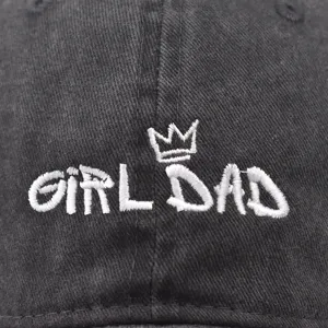Close-up detail of vintage washed baseball cap featuring white embroidered crown and text.