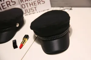 Black newsboy cap detail shot, PU leather brim and braided band design, vintage retro style.