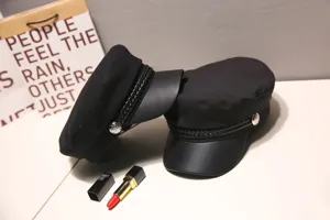 Detail view of black newsboy cap with leather brim and braided trim for women fashion.