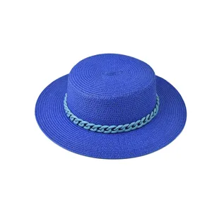 Nahaufnahme des stilvollen blauen Strohhutes mit einzigartigem Kettendekor im Sommer.