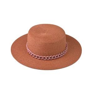 Nahaufnahme des stylischen Damen Sommer Strohhuts mit schicker rosa Kette und flacher Krempe.