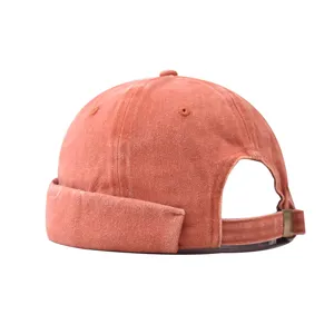 Detailed view of the washed orange brimless docker cap showcasing its texture and metal buckle.
