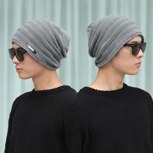 Bonnet d'hiver en tricot gris pour hommes et femmes, avec détail de badge en métal.