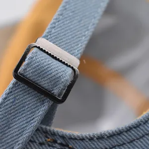 Gros plan detail de la sangle de casquette de baseball en jean et boucle metal.