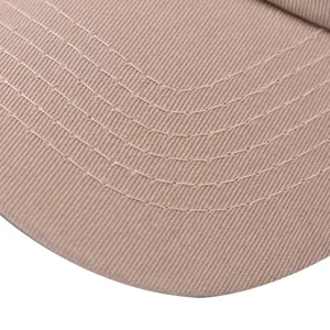 Primo piano della visiera del berretto in cotone kaki con cuciture ordinate e resistenti.