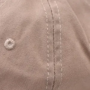 Primo piano dettagliato sulla trama del tessuto e sulle cuciture di un berretto in cotone.