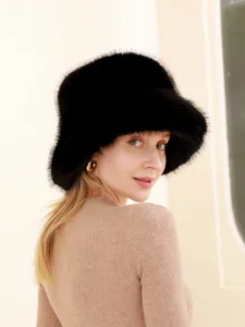 Close-up detail of women's black fluffy fox fur winter warm bucket hat plush texture.