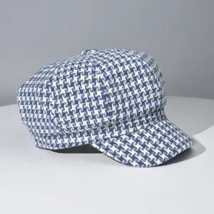 Detailed view of the blue and white houndstooth newsboy cap, classic pattern chic beret hat.