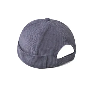 Corduroy docker cap detail view, textured brimless melon hat back adjustable strap closeup.