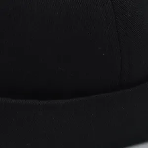 Κοντινό πλάνο μαύρου υφάσματος twill και καθαρών ραφών σε ένα κλασικό σκουφάκι.