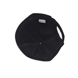 Detailed view of the inner lining and wash label of a black corduroy docker cap.