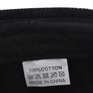 Corduroy cap inner wash label detail showing 100 percent cotton material and origin info.