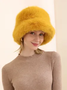 Close-up detail of fluffy yellow plush bucket hat, soft texture and stylish winter design.