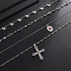 Vue détaillée de l'ensemble de colliers superposés à 4 rangs avec croix et pendentifs étoiles.
