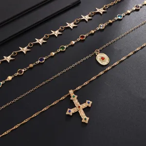 Vue détaillée du collier doré à quatre rangs superposés avec croix et pendentifs étoiles.