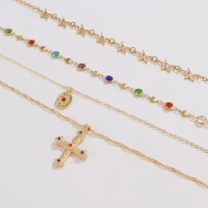 Vue détaillée du set de colliers dorés à quatre couches avec pendentifs étoiles et pierres.