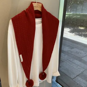 Red knit triangle scarf for women, hollow design with pom-poms, stylish winter warm shawl.