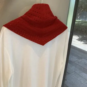 Detail shot of a red hollow-out knitted triangular scarf shawl for women layering.