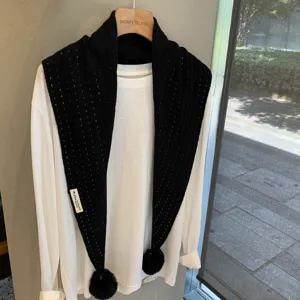 Black hollow knit wool triangular scarf with cute pom poms, stylish winter warm accessory.
