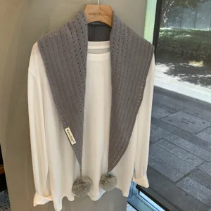 Grey wool knit triangle scarf with pom poms, versatile fashion winter layering accessory.