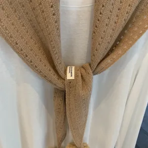 Detailed view of women's hollow knit wool cashmere triangular scarf in cozy camel texture