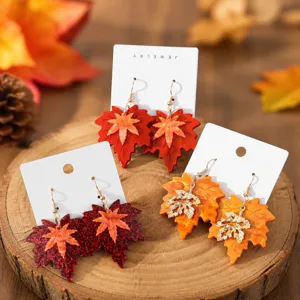 Close-up detail of double-layer resin maple leaf earrings, retro autumn style ear hooks.