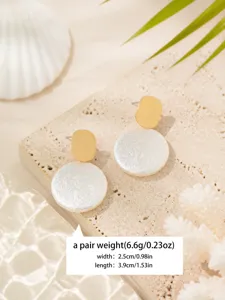 Detailed close-up of French textured round pearl earrings with golden top and white drop.