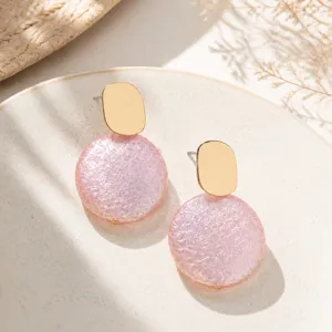 Pink pearlescent textured geometric earrings detail showcasing elegant gold and pink round design.