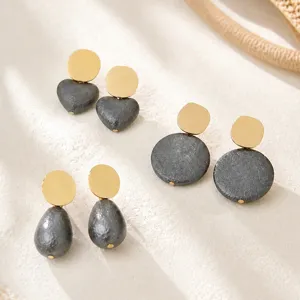 Dark grey textured vintage earrings featuring gold disc with heart and round drop designs.