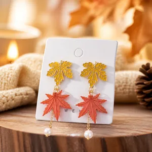 Autumn maple leaf pearl earrings detail shot, cozy forest style jewelry close up view.