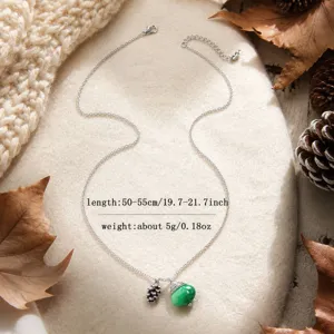 Detailed view of silver chain necklace featuring a green sea glass pendant and cute pinecone charm.