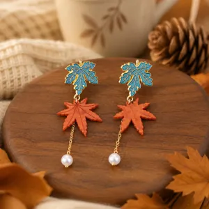 Detailed shot of autumn maple leaf pearl dangle earrings with forest style and elegant charm.