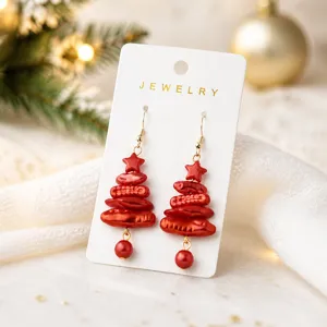 Detailed close-up of red irregular imitation pearl Christmas tree earrings with star pendant.
