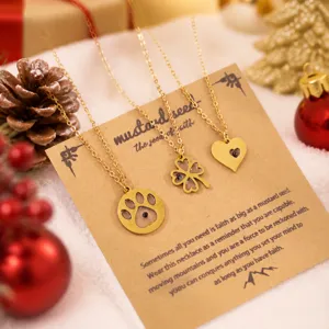 Ensemble de collier pendentif multi-motifs en acier inoxydable sur une carte cadeau de Noël.