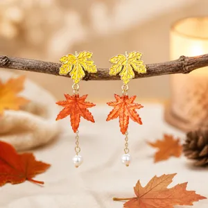 Close-up detail of autumn maple leaf pearl drop earrings with warm forest aesthetic.
