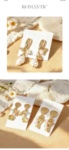 Détail boucles d'oreilles perle coquillage style océan tropical, bijoux mode plage été.